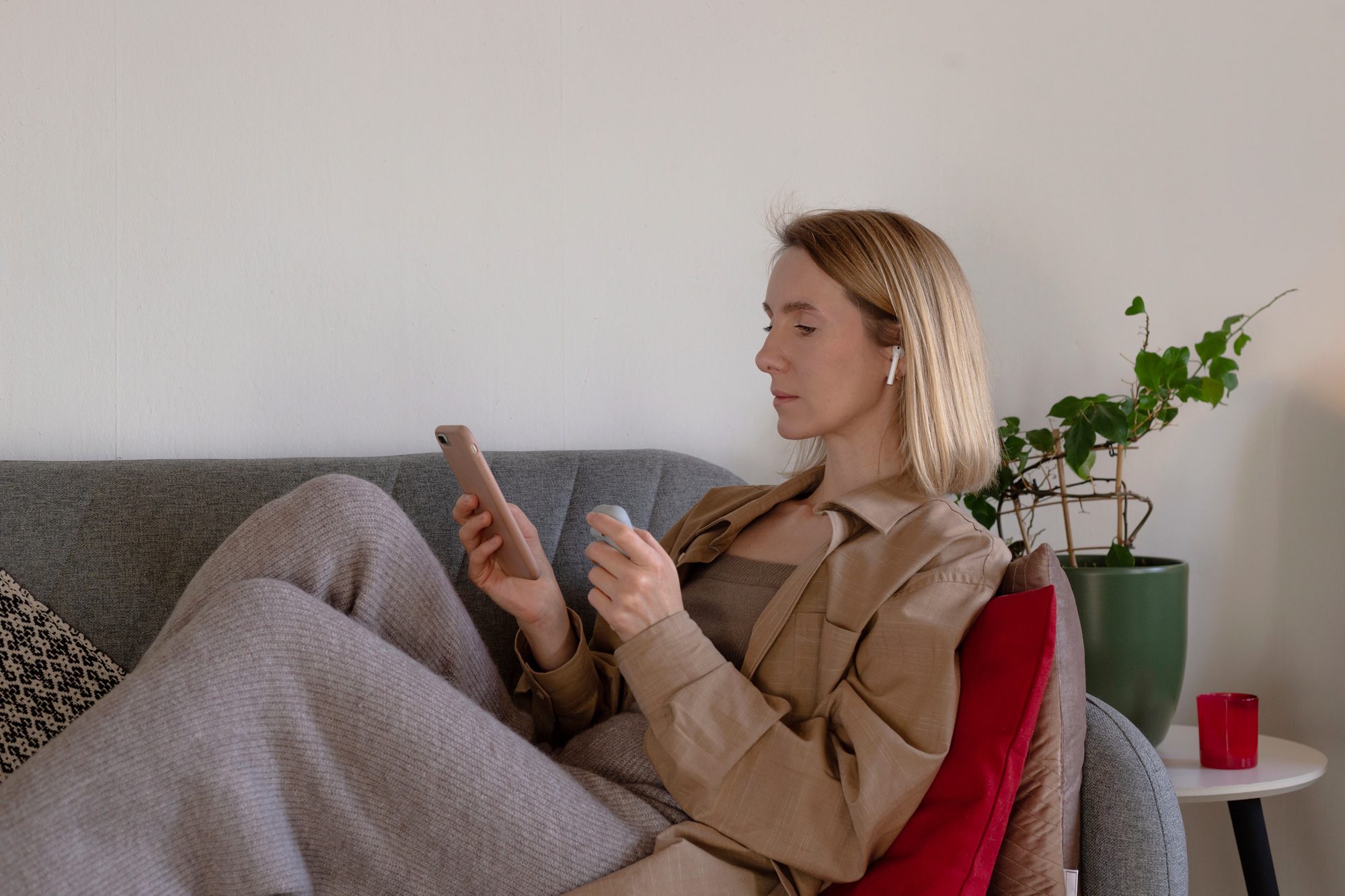 Woman at home resting and listening to podcast with headphones.